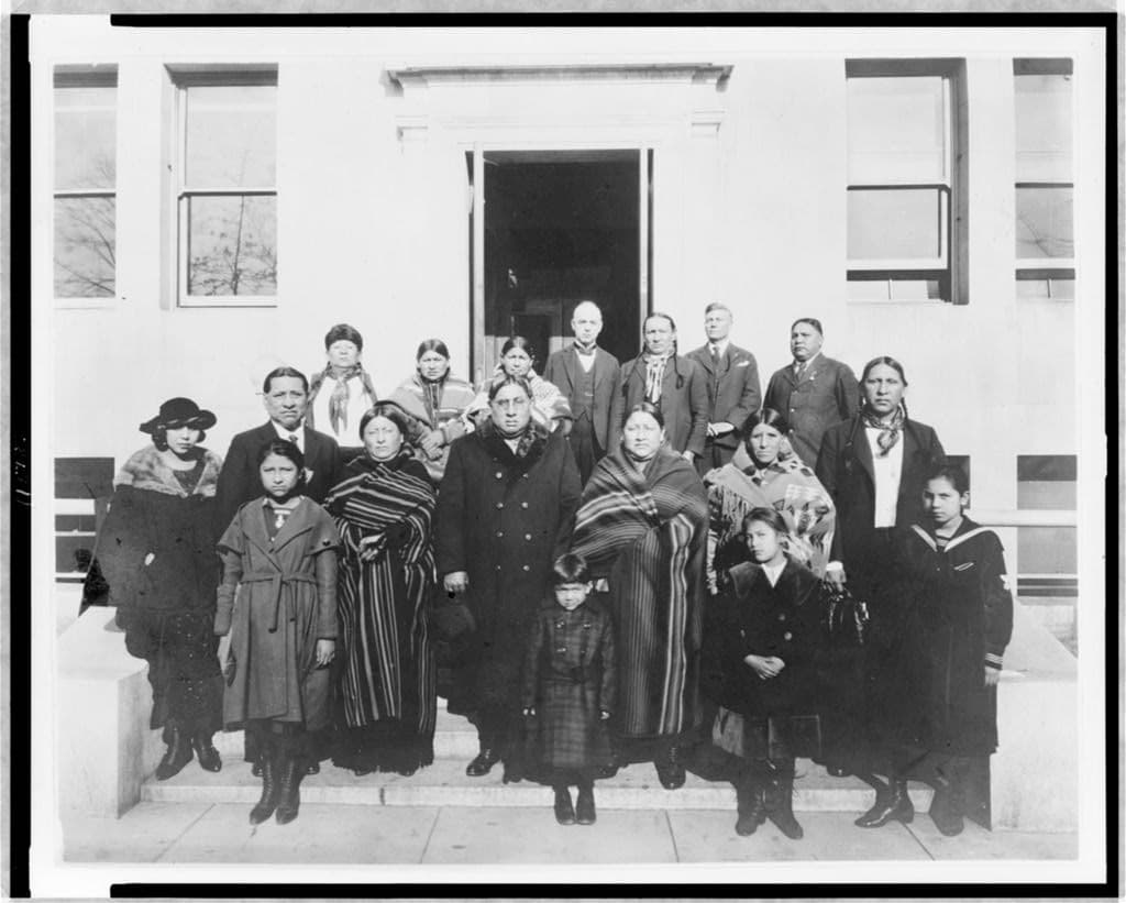 Fifteen Osage on the steps in Washington about 1920. The record names Franklin Revard and Chief Bacon Rind.