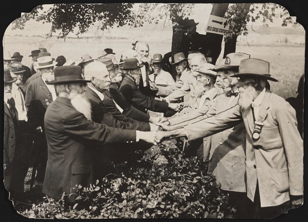 Union and Confederate veterans shake hands. The record does not say where on the field.