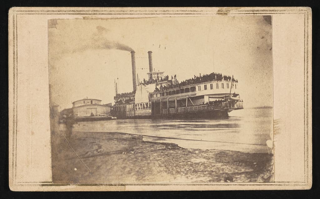A period carte de visite of the same scene, her decks packed with released prisoners.