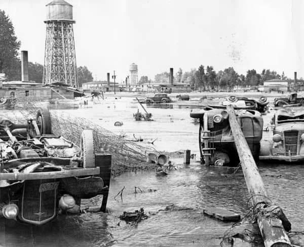 Overturned cars below the same water tower that stands in the 1943 photograph.