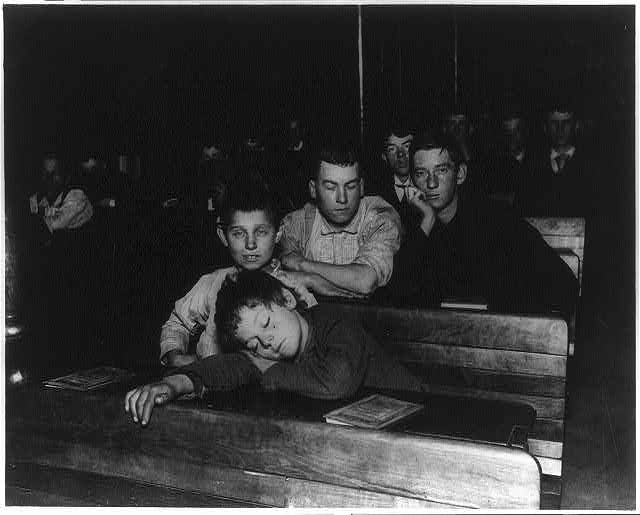 Night school in the Seventh Avenue lodging house. One boy has put his head down on the desk.