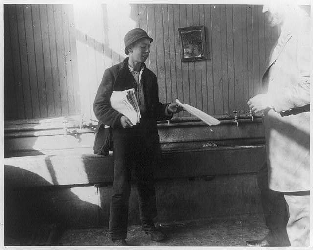 A newsboy in the Duane Street Lodging House, about 1889.