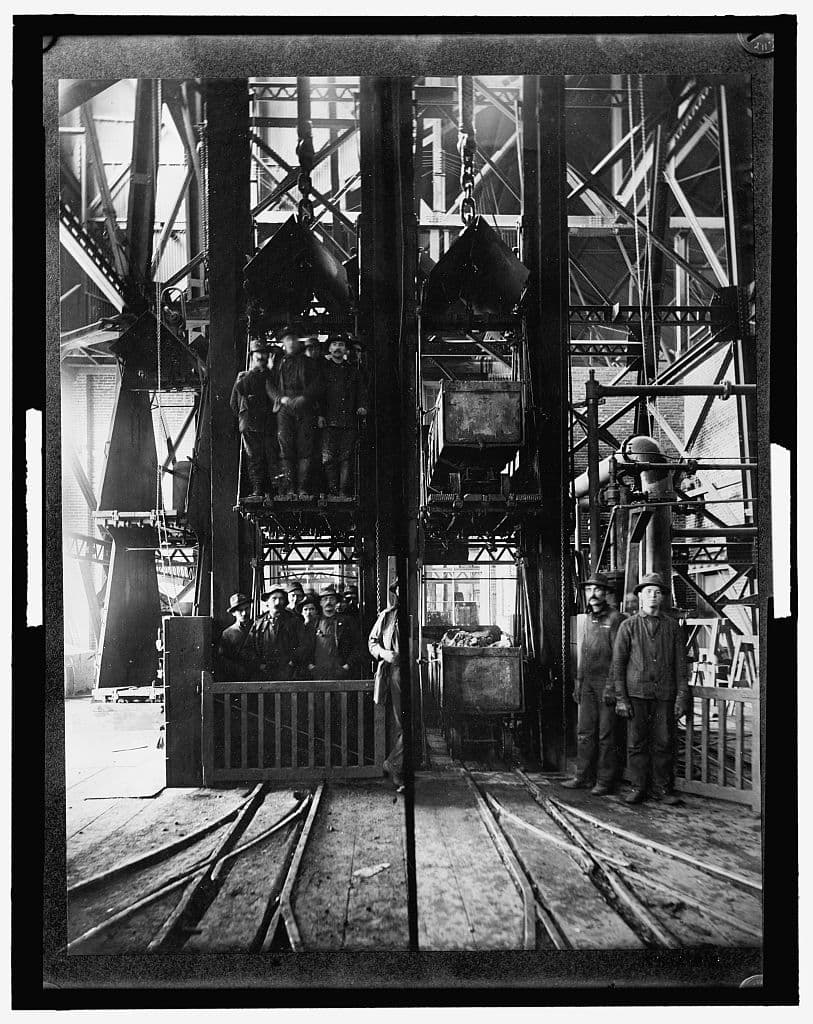 Hoisting ore and lowering miners at the shaft head, between 1900 and 1910.