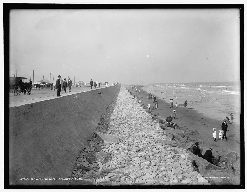 The finished seawall and the beach below it, with the city behind on its raised grade.